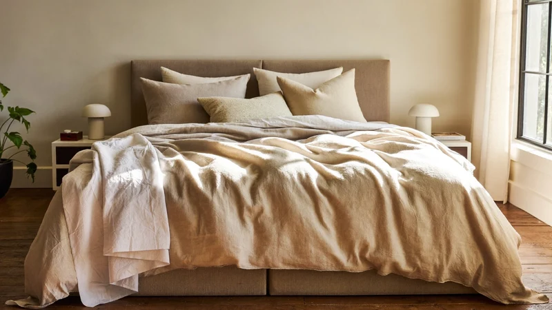 Helles Schlafzimmer mit frisch bezogenem Bett in neutraler Leinenbettwäsche, Illustration